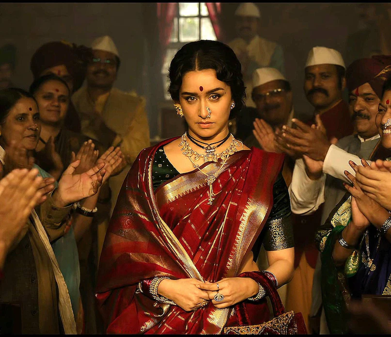 Shraddha Kapoor’s transformation in the teaser has drawn immediate attention. Dressed in a traditional Nauvari-style saree with bold jewellery and stage-ready styling, her look is widely seen as inspired by Vithabai Narayangaonkar’s iconic stage presence, reflecting the grandeur and energy of Lavani performance. Shraddha Kapoor’s transformation in the teaser has drawn immediate attention. Dressed in a traditional Nauvari-style saree with bold jewellery and stage-ready styling, her look is widely seen as inspired by Vithabai Narayangaonkar’s iconic stage presence, reflecting the grandeur and energy of Lavani performance.